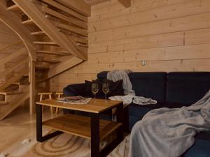 a living room with a couch and a table with wine glasses at Domki Michelle in Wisła
