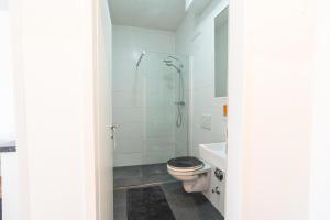 Un baño blanco con inodoro y ducha. en Alps Studio, en Innsbruck