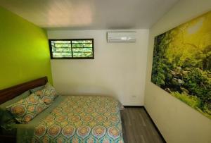 a bedroom with a bed and a painting on the wall at Pura Vida - Villa Lisa in Parrita