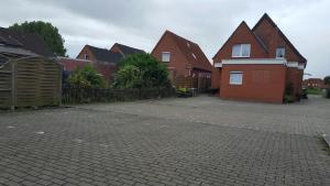 eine Reihe von Häusern in einer Backsteinstraße in der Unterkunft Pension Nordsee in Norddeich