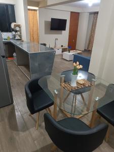 una sala de estar con una mesa y sillas de cristal en DEPPIu, en Piura
