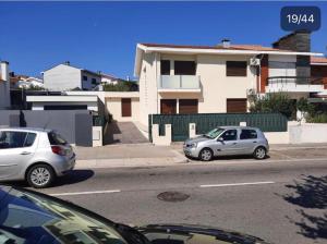 zwei Autos, die am Straßenrand geparkt sind in der Unterkunft Maia Oporto Suites in Maia
