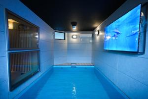 uma piscina com televisão e um aquário em SEADINERS VILLA AOYAMA Tokyo First Metropolis Villa Pool Sauna BBQ em Tóquio mais 59 fotografias