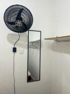 サルバドールにあるQuarto individual na Pitubaの壁に掛けられた鏡と扇風機 +13枚の写真