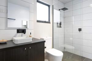 ein weißes Badezimmer mit Toilette und Waschbecken in der Unterkunft Spacious 1-Bed Townhouse in Norlane in Norlane