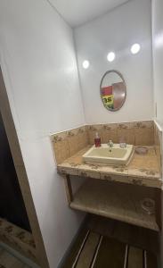 un baño con lavabo y espejo en Delva's Villa, en Ciudad de Belice 1 foto más