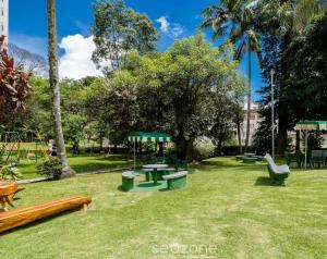 park ze stołami piknikowymi i placem zabaw w obiekcie Apartamento 122 no Condomínio Quisisana w mieście Poços de Caldas