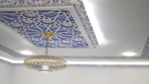 a chandelier hanging from a blue and white ceiling at Dar Ouadie the pearl stay in Chefchaouen