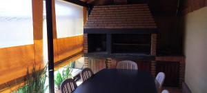 ein Tisch und Stühle auf einem Balkon mit einem Steinofen in der Unterkunft La Emilia Casa de Vacaciones con Pileta y Quincho in Salta