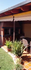 eine Terrasse mit zwei Stühlen und einem Sonnenschirm in der Unterkunft La Emilia Casa de Vacaciones con Pileta y Quincho in Salta