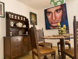 a dining room with a table and a painting on the wall at Casa Dos Hermanas in Guanajuato