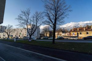 Una calle de la ciudad con árboles y montañas al fondo. en Alps Studio, en Innsbruck