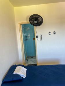 サルバドールにあるQuarto individual com suíte na Pitubaの青いベッドとシャワーのある部屋