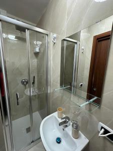une salle de bain avec un lavabo blanc et une douche dans l'établissement Silvana House, à Naples
