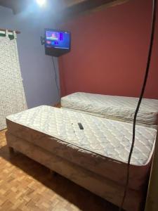 Bett in einem Zimmer mit einem TV an der Wand in der Unterkunft Florencia in Miramar