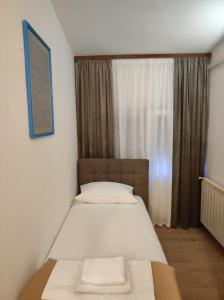 a bedroom with a bed with two towels on it at Rooms San in Velika Gorica