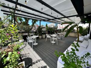 a patio with white chairs and tables and plants at Casa Verde Boutique Hotel in Santa Marta