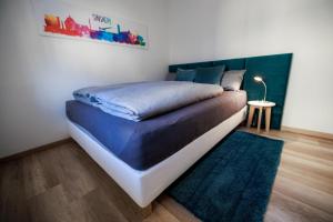 ein Schlafzimmer mit einem Bett mit einer blauen Decke und einem Teppich in der Unterkunft Stylishes Premium Apartment in Sinsheim