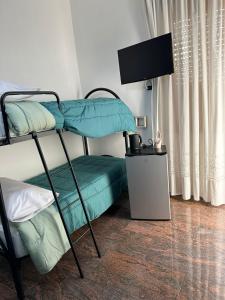 une chambre avec deux lits superposés et une télévision à écran plat dans l'établissement Silvana House, à Naples