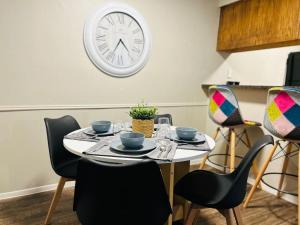 a table with chairs and a clock on the wall at KING bed central worker-friendly LongStayDiscount in Sherman