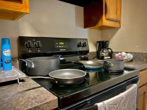 a kitchen stove with three pots and pans on it at KING bed central worker-friendly LongStayDiscount in Sherman