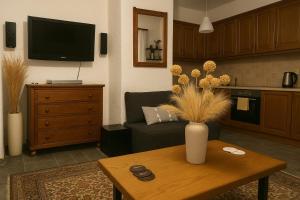 a living room with a vase of flowers on a table at Billy's Place in Aegina Town