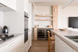 a kitchen with white cabinets and a counter top at Monet by Khove - Kirra Beach in Gold Coast