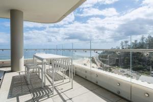 a balcony with chairs and a view of the ocean at Monet by Khove - Kirra Beach in Gold Coast