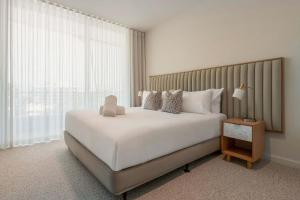 a bedroom with a large white bed and a window at Monet by Khove - Kirra Beach in Gold Coast +18 photos