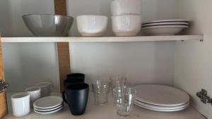 a shelf filled with bowls and cups and plates at Merlo ink3 in Merlo