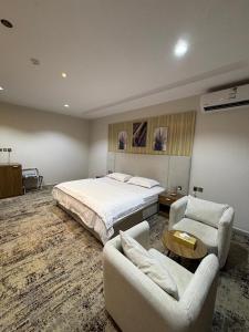 a hotel room with a bed and two chairs at واحه فدك للشقق المخدومه in Al Ḩāyiţ +32 photos