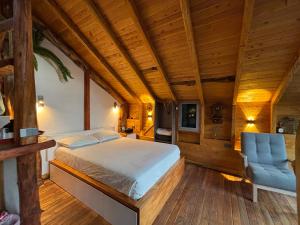 Un dormitorio con una cama y una silla azul. en PrivaDune, en Rionegro