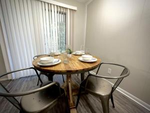 a wooden table with chairs and glasses on it at KINGbed A plus location A plus for workers LongStayDiscount in Sherman