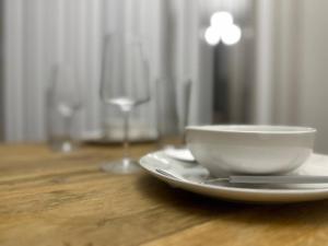 a white bowl on a plate on a table with a wine glass at KINGbed A plus location A plus for workers LongStayDiscount in Sherman