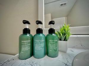 two green shampoo bottles sitting on top of a counter at KINGbed A plus location A plus for workers LongStayDiscount in Sherman +5 photos
