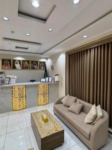 a living room with a couch and a table at واحه فدك للشقق المخدومه in Al Ḩāyiţ