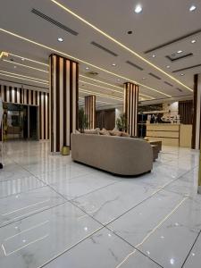 a lobby with a couch in the middle of a building at واحه فدك للشقق المخدومه in Al Ḩāyiţ