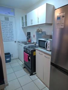 a small kitchen with a stove and a refrigerator at Departamento Familiar a 5 min centro in Rancagua