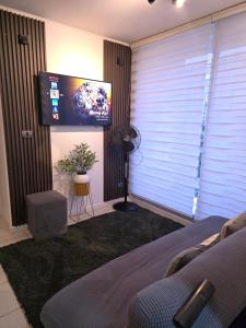 a living room with a tv and a bed and a window at Departamento Familiar a 5 min centro in Rancagua