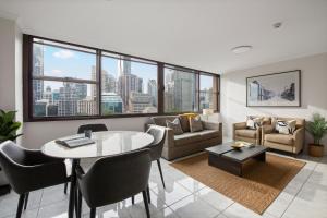 una sala de estar con una mesa y un sofá en City Escape with Spa Access in Darlinghurst, en Sídney
