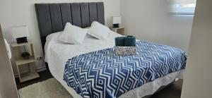 a bedroom with a bed with a blue and white comforter at Departamento Familiar a 5 min centro in Rancagua