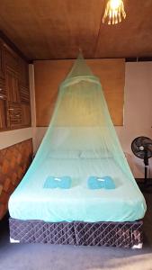 Una cama con una red encima en una habitación. en Plancton House Atins, en Atins