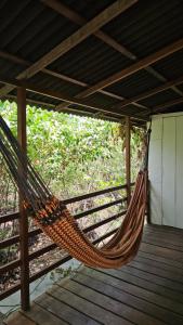 a hammock on a porch with a wooden deck at Plancton House Atins in Atins