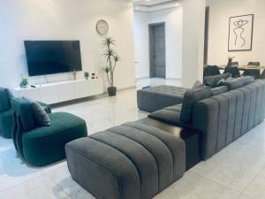 a living room with couches and a flat screen tv at Golden apartment in Lagos