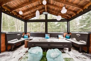 a screened in porch with benches and a table at Alpha Ö - Chalet Spa et detente in Petite-Rivière-Saint-François