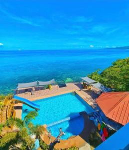 an aerial view of a swimming pool and the ocean at Sacaan Tropical Breeze Resort in Sogod