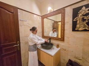 Eine Frau, die in einem Waschbecken im Bad steht. in der Unterkunft Bali Emerald Apartments in Sanur + 154 Fotos