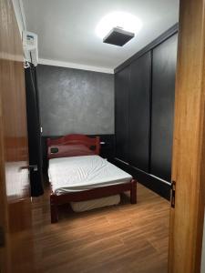 a small bed in a room with a black wall at Casa Encanto in Franca +18 photos