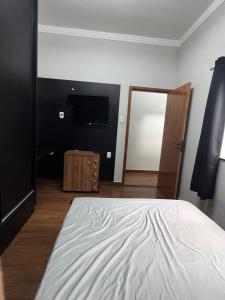 een slaapkamer met een groot bed en een televisie bij Casa Encanto in Franca +18 foto's