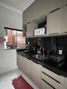 a kitchen with a sink and a microwave at Casa Encanto in Franca